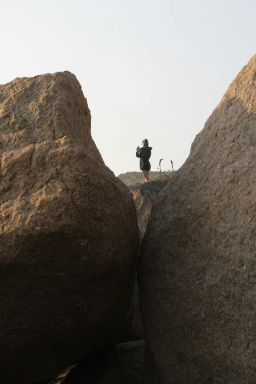 a man in black jacket standing on rocks