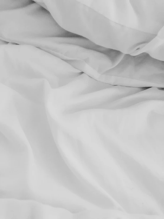 an unmade bed with white sheets and a pillow