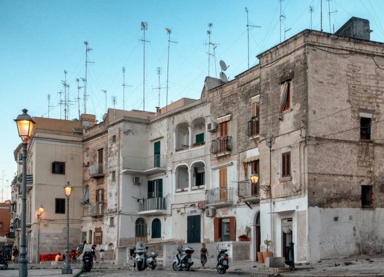 a motorcyclist and two pedestrians are on the street near an old building