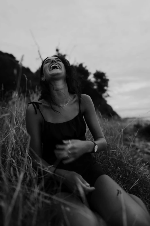 a woman sitting on a lush green field