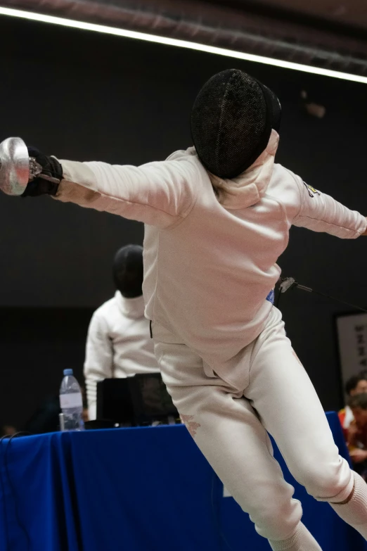 the person is practicing fencing with his arms spread