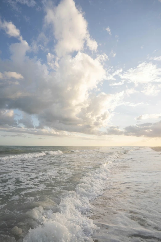 the sun shines through clouds over a body of water