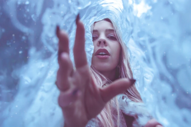 a woman with long hair making the v hand gesture