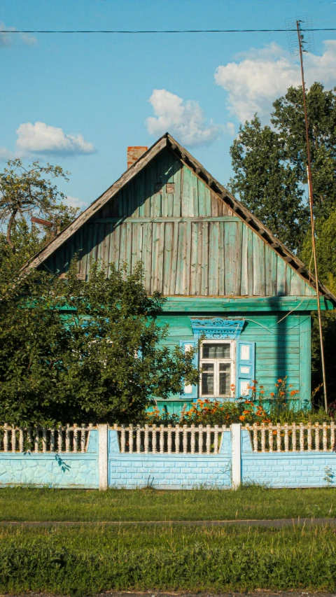 the wooden house is behind a picket fence