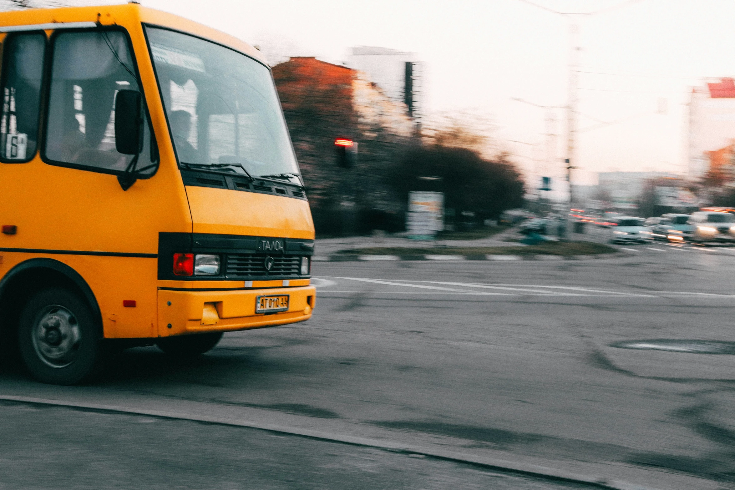 there is a yellow bus driving down the street