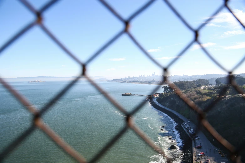 view from inside the fence looking down over a beach and ocean