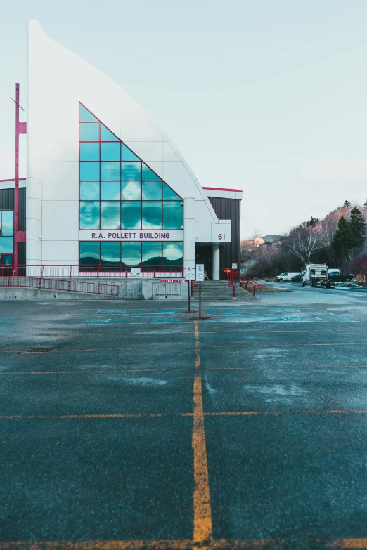 a large white building with a red fence on one side