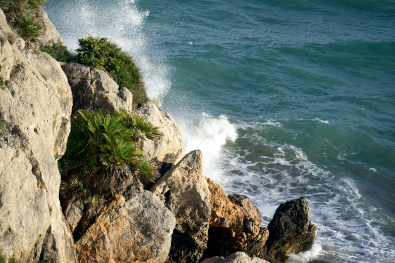 the water splashes against the rocks on the beach