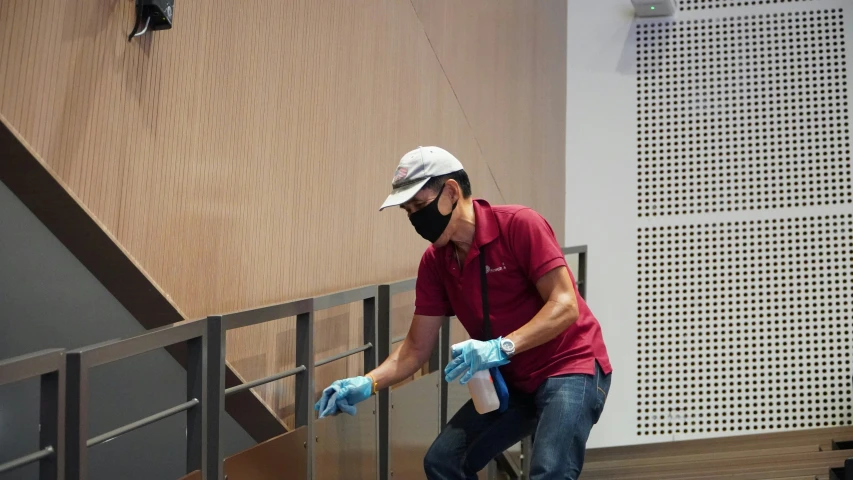 the man wearing gloves is cleaning a wall with a rag