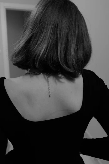 a woman wearing a necklace from the back