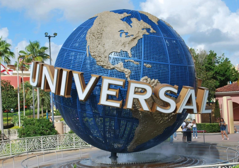 a po taken with a big blue globe with the word universal and a man walking beside it