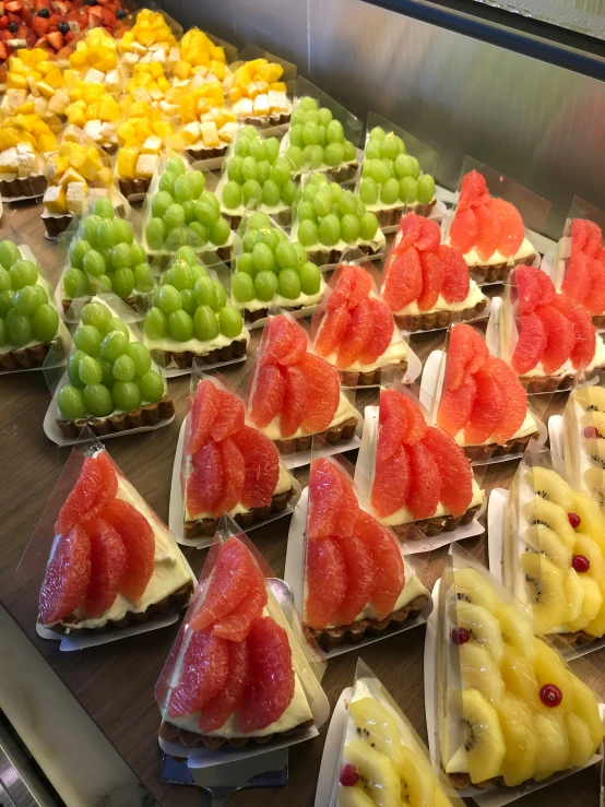 many small tarts are lined up on display