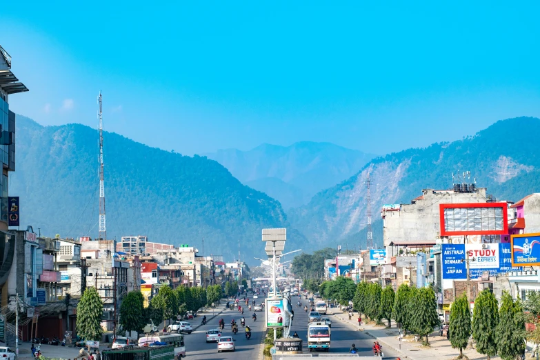 cars are driving down a busy street in the mountains