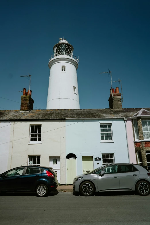 a lighthouse and cars are parked next to each other