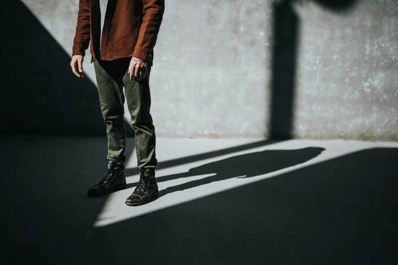 a man standing in front of a cement wall