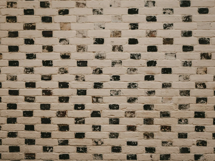 a white and black tiled wall in an urban location