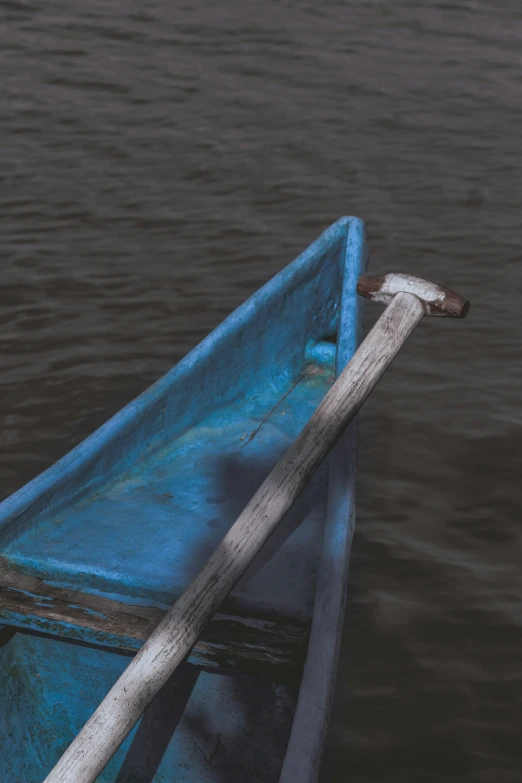 a blue boat with a stick in the water