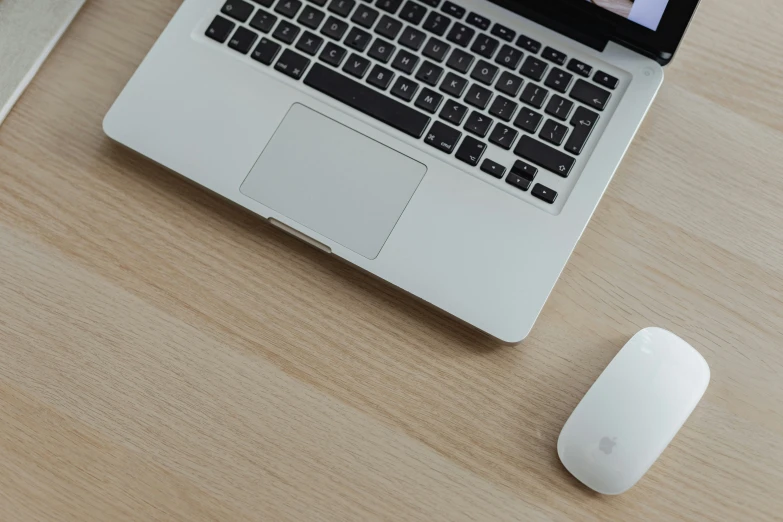 an open laptop and computer mouse sitting on a desk