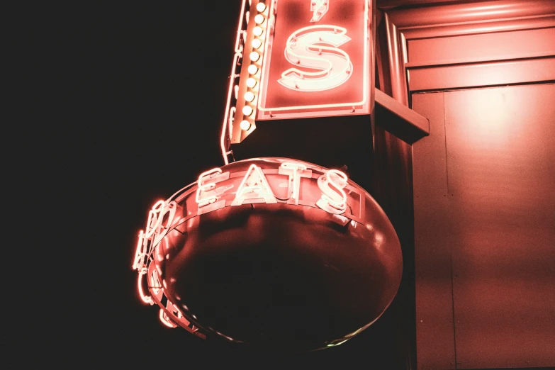 a restaurant sign hanging on the side of a building