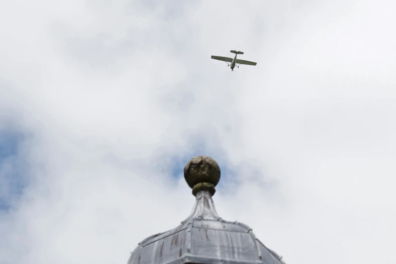 an old fashioned plane flying near some big buildings