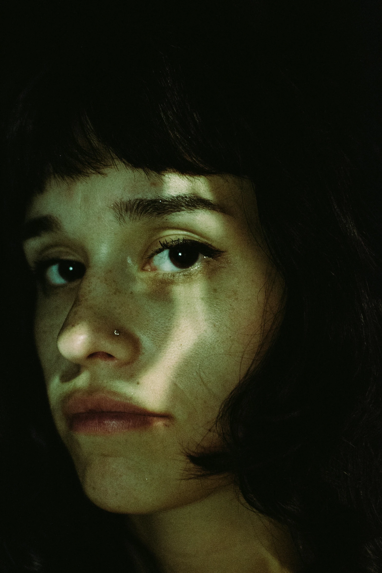 young woman with dark brown hair staring away