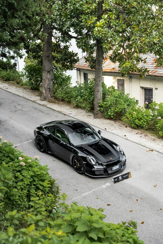 this black bmw is parked in front of a house