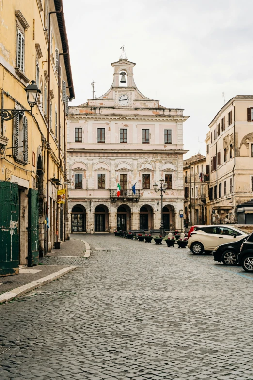 a narrow street with cars parked in the middle