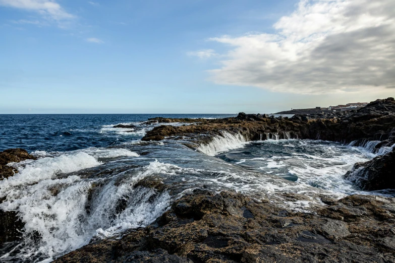 the water is splashing all over the rock wall