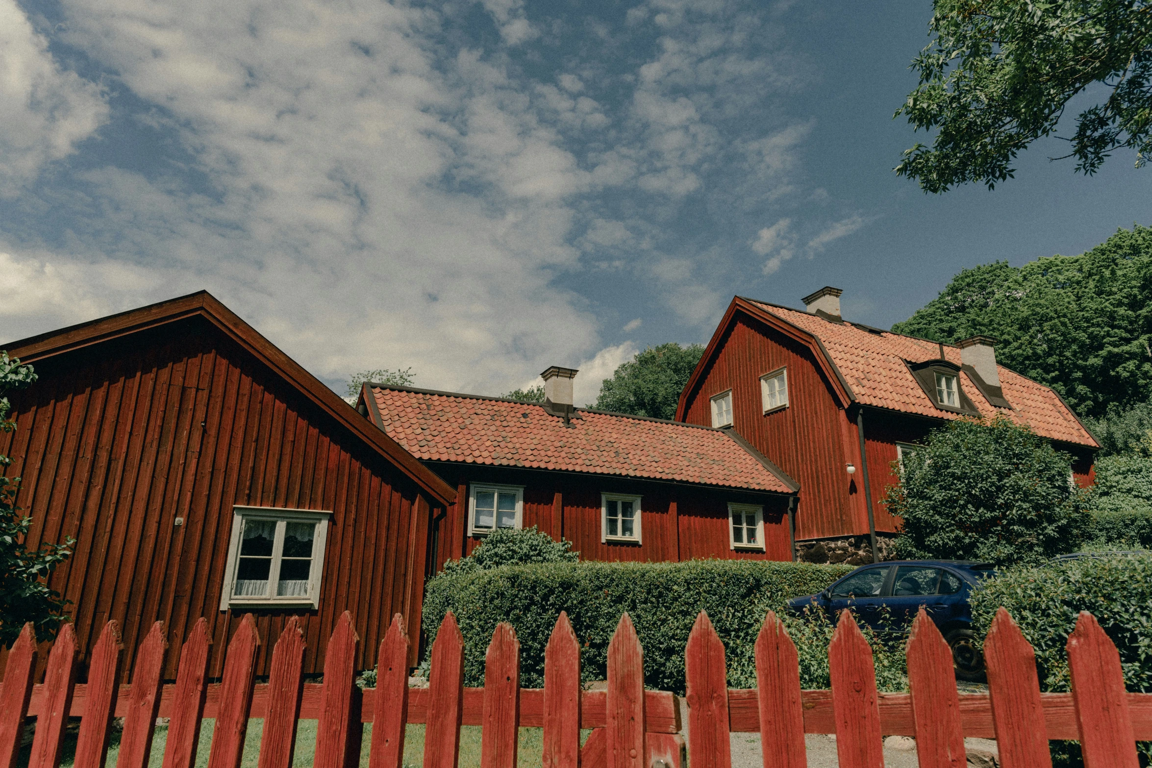 a home with a red picket fence in front