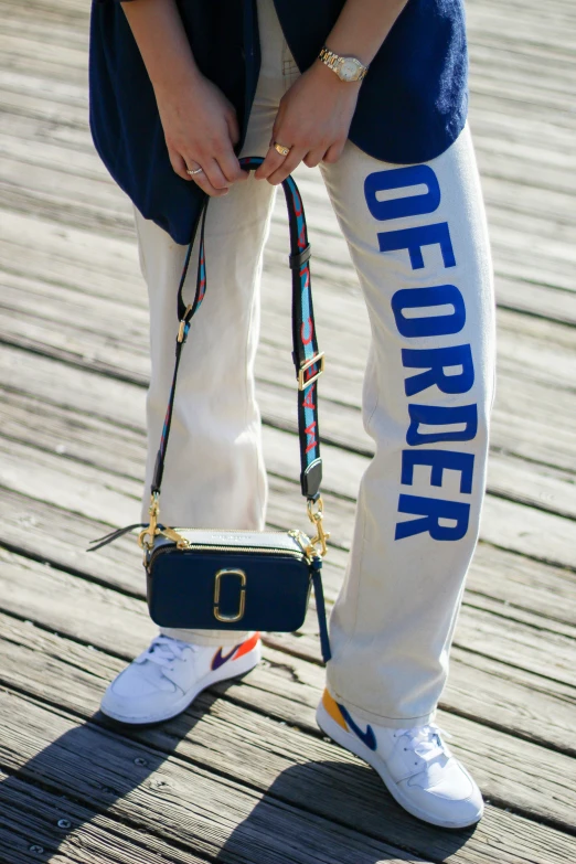 a woman's leg holding onto the wrist bag while standing on the ground