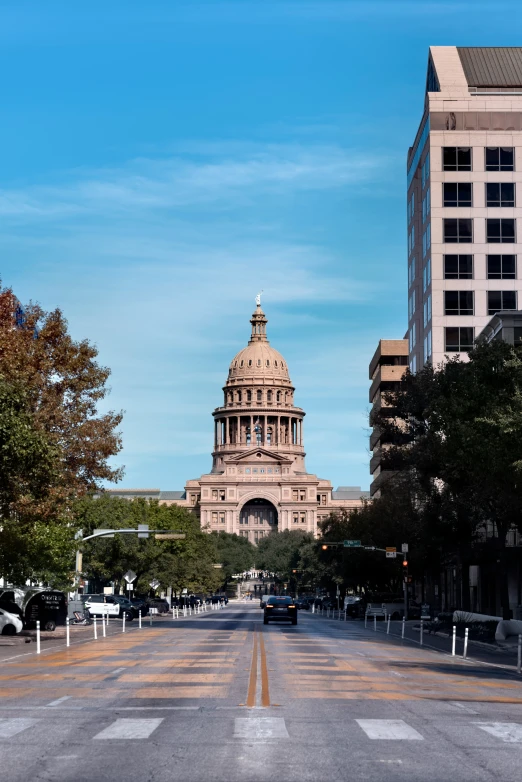 the tall clock tower stands in the center of a city street