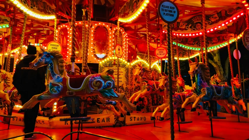 a brightly lit carousel with horses and holiday decorations