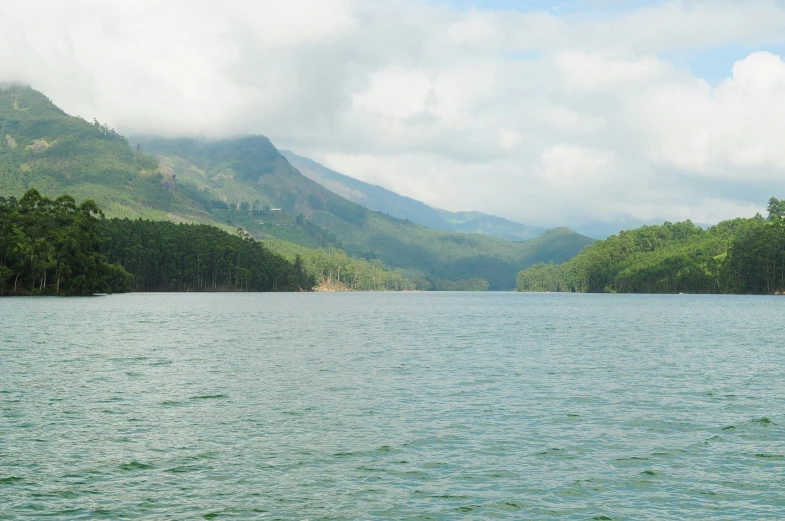 a view of the water from a distance with mountains in the background