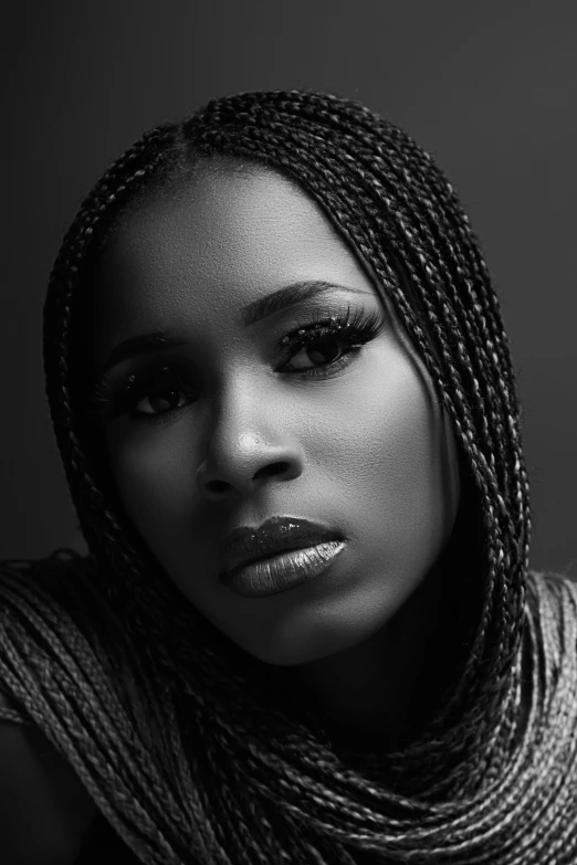 a woman with a dreadlock on her head wearing grey and white