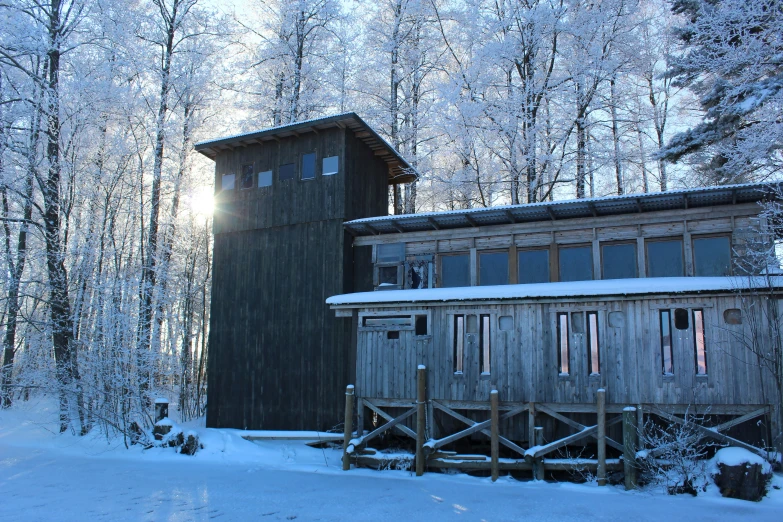 a house stands in the snow surrounded by trees