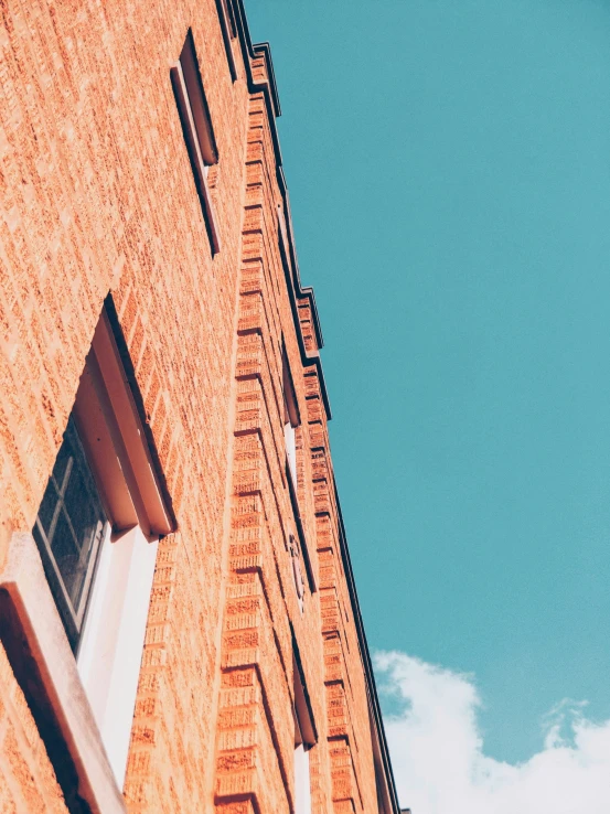 a very tall brick building with a street sign above it