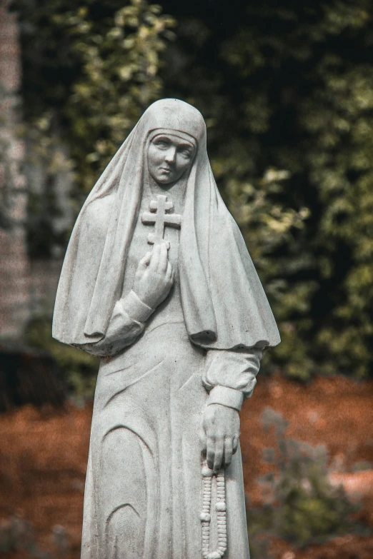 a statue of the nun sitting on top of a base