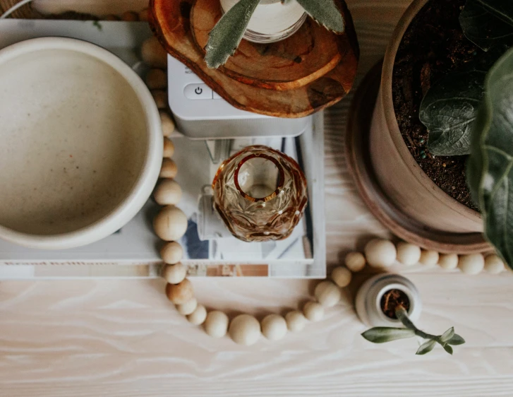 a set of dishes are sitting next to beads and a vase