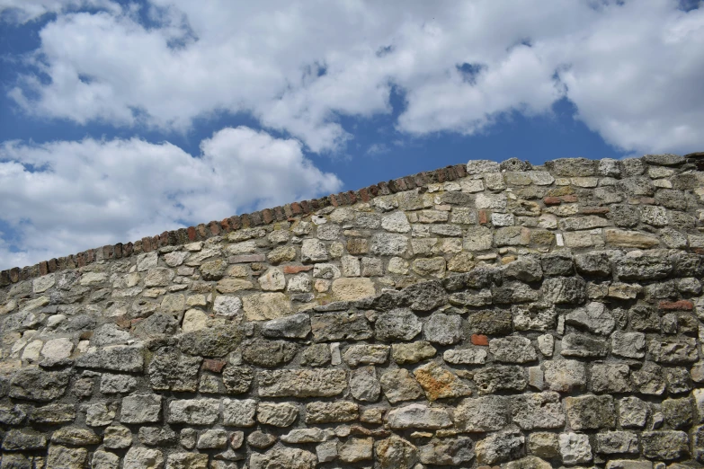 a stop sign on the top of a stone wall