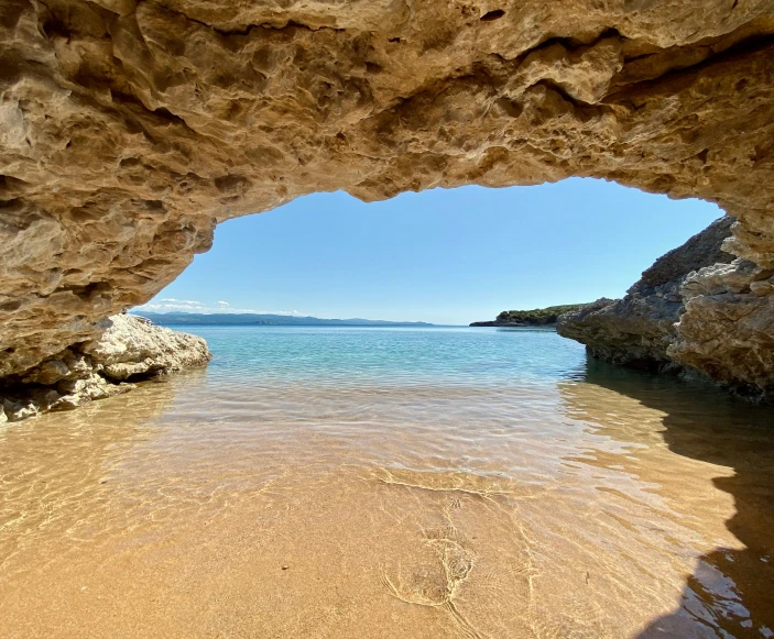 a man wading into some water and a large stone