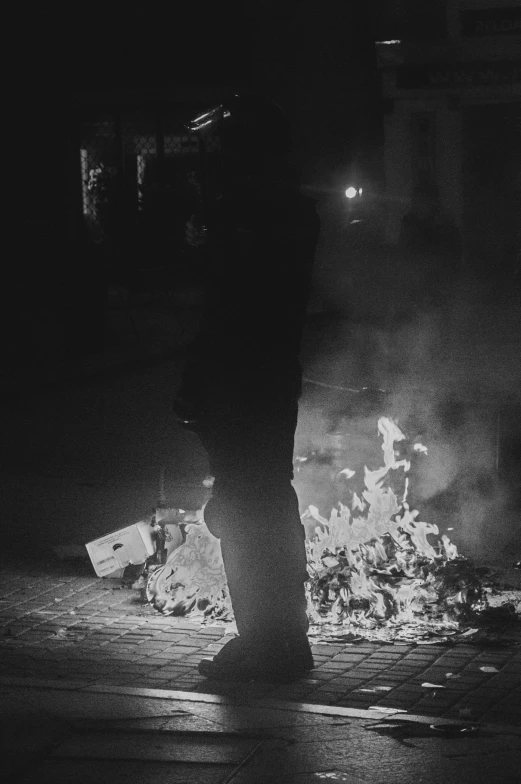 man walking in the dark on the street with his bag of belongings