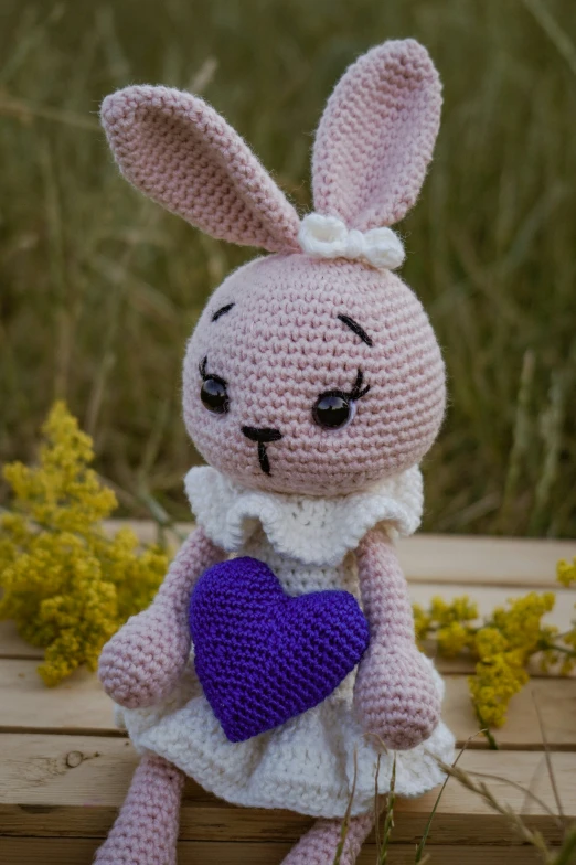 a cute crocheted bunny with a purple heart