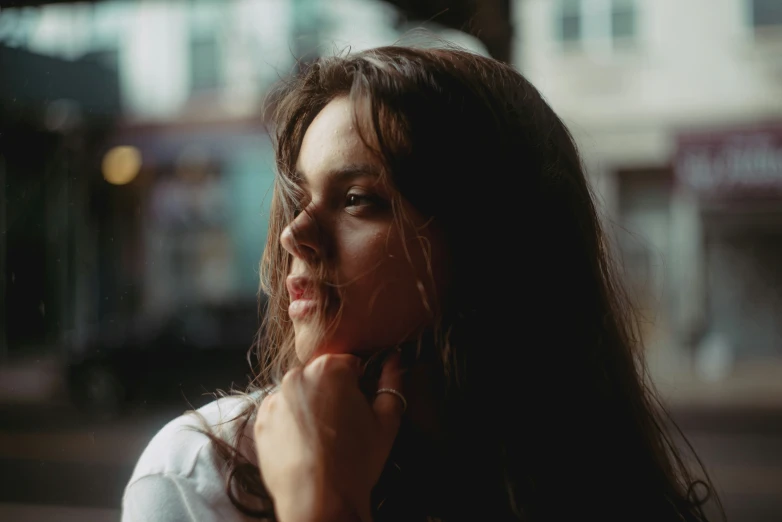 a woman holding a cigarette looks away from the camera