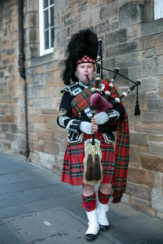 a male in a kilt with some bagpipes