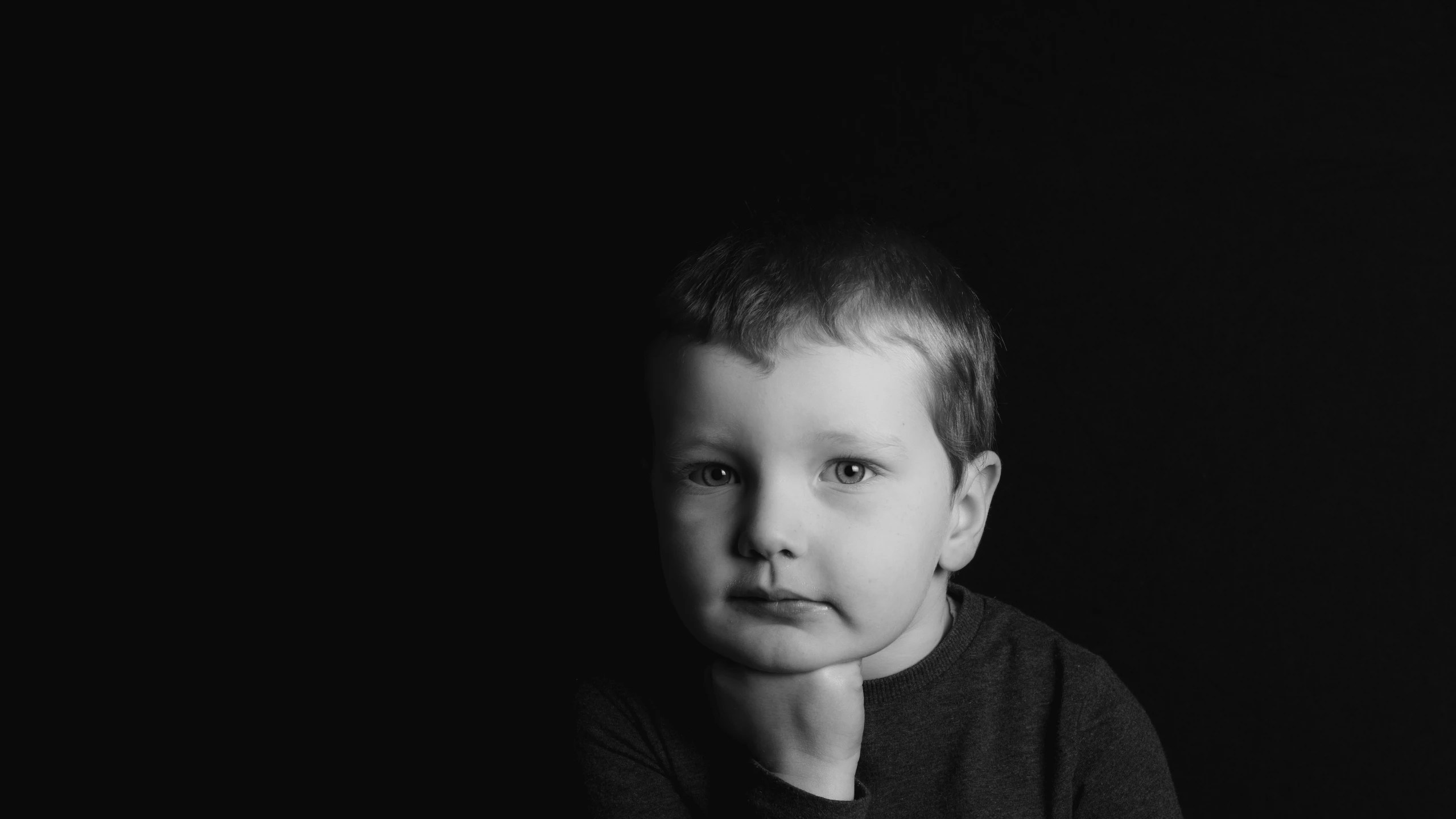 black and white pograph of a child in a dark room