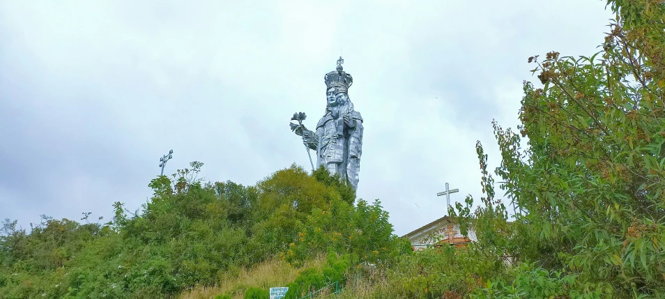 a statue in the middle of a lush green field