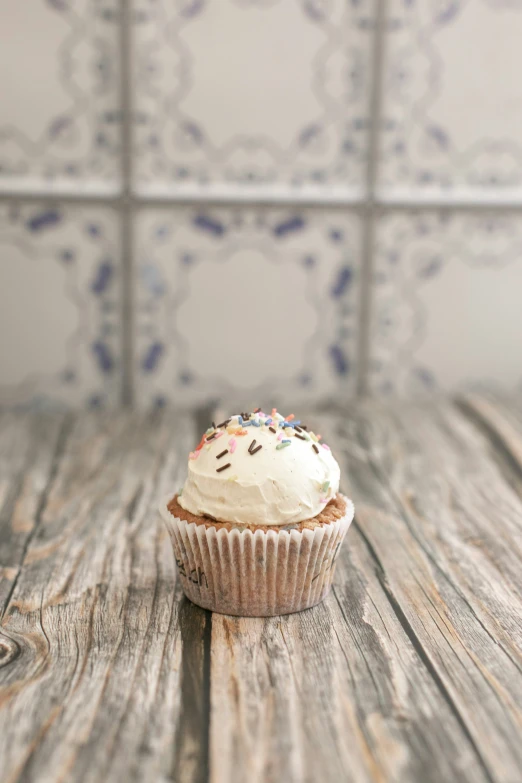 a cupcake with chocolate icing on it is sitting on a table