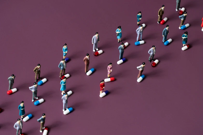 many miniature toy people are standing next to each other