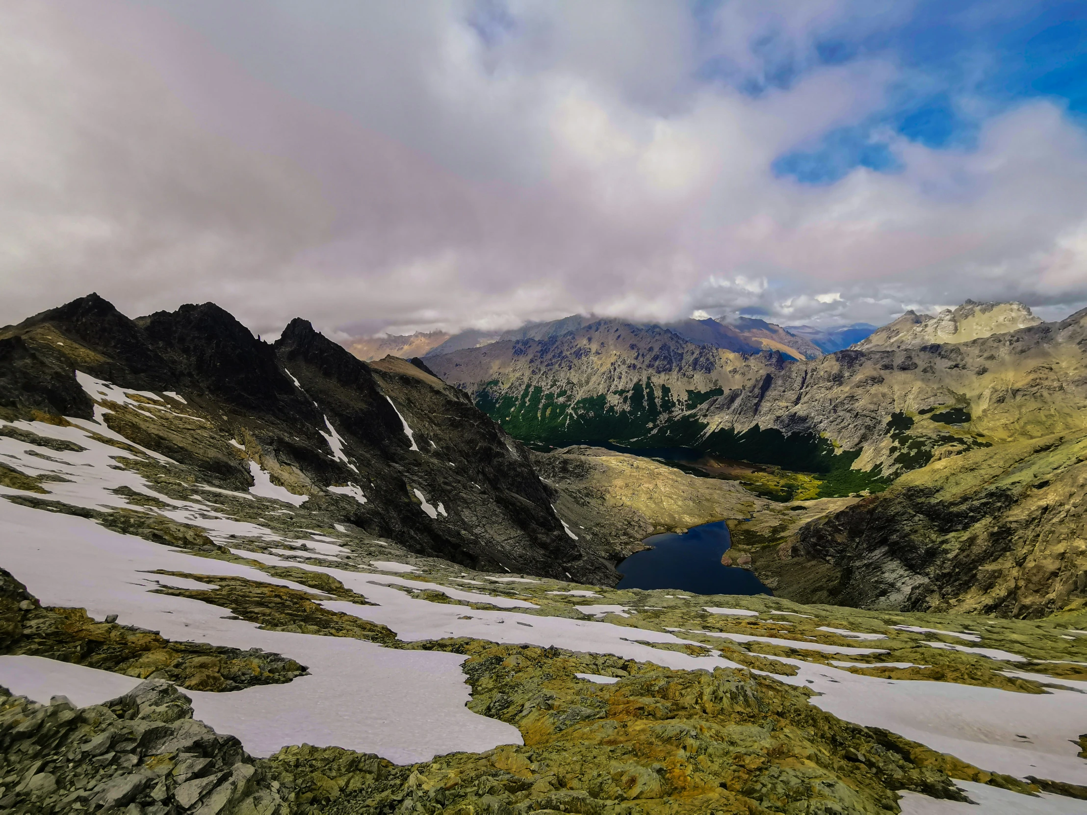 the snowy mountain landscape is seen with mountains in the distance