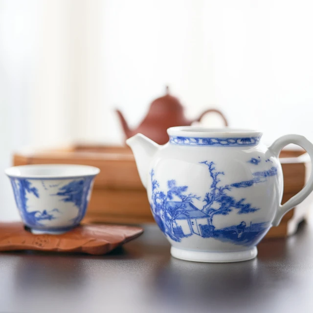 there is a white tea set with blue florals on the saucer and bowl